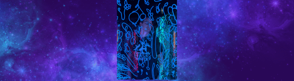 Eine Person in einem Museum hinter Glas, blau beleuchtet, nachdenklich