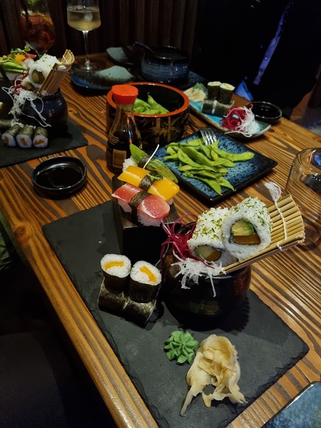 Ein Tisch in einem Restaurant mit mehreren Sushi-Platten darauf