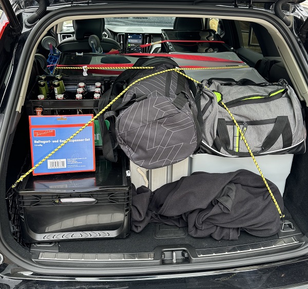 Aufnahme eines voll gepackten Kofferraums mit Reisetaschen, Kunststoffboxen und mehr.